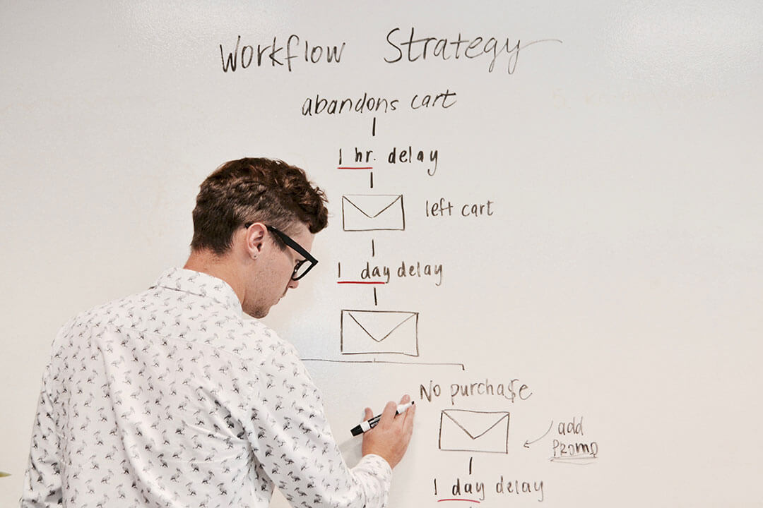 Writing online campaign strategy on whiteboard Person writing schematic online campaign strategy on whiteboard