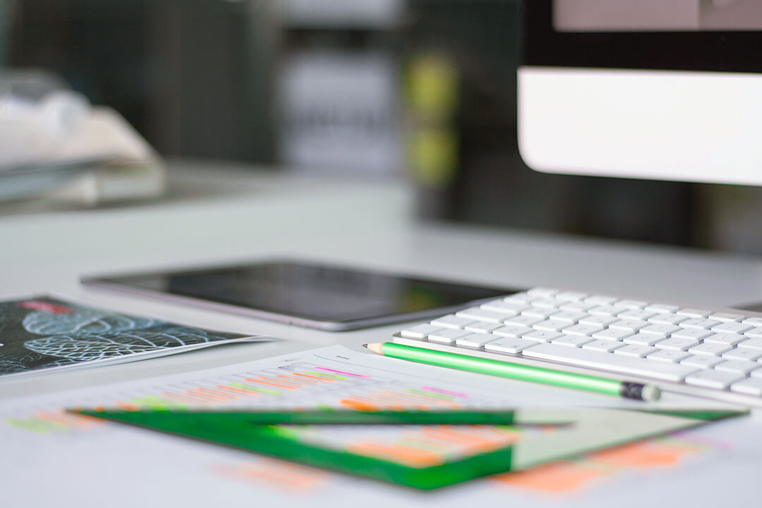 Workspace with wireframes of website design, a tablet and keyboard