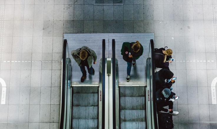 People on escalator using smartphones
